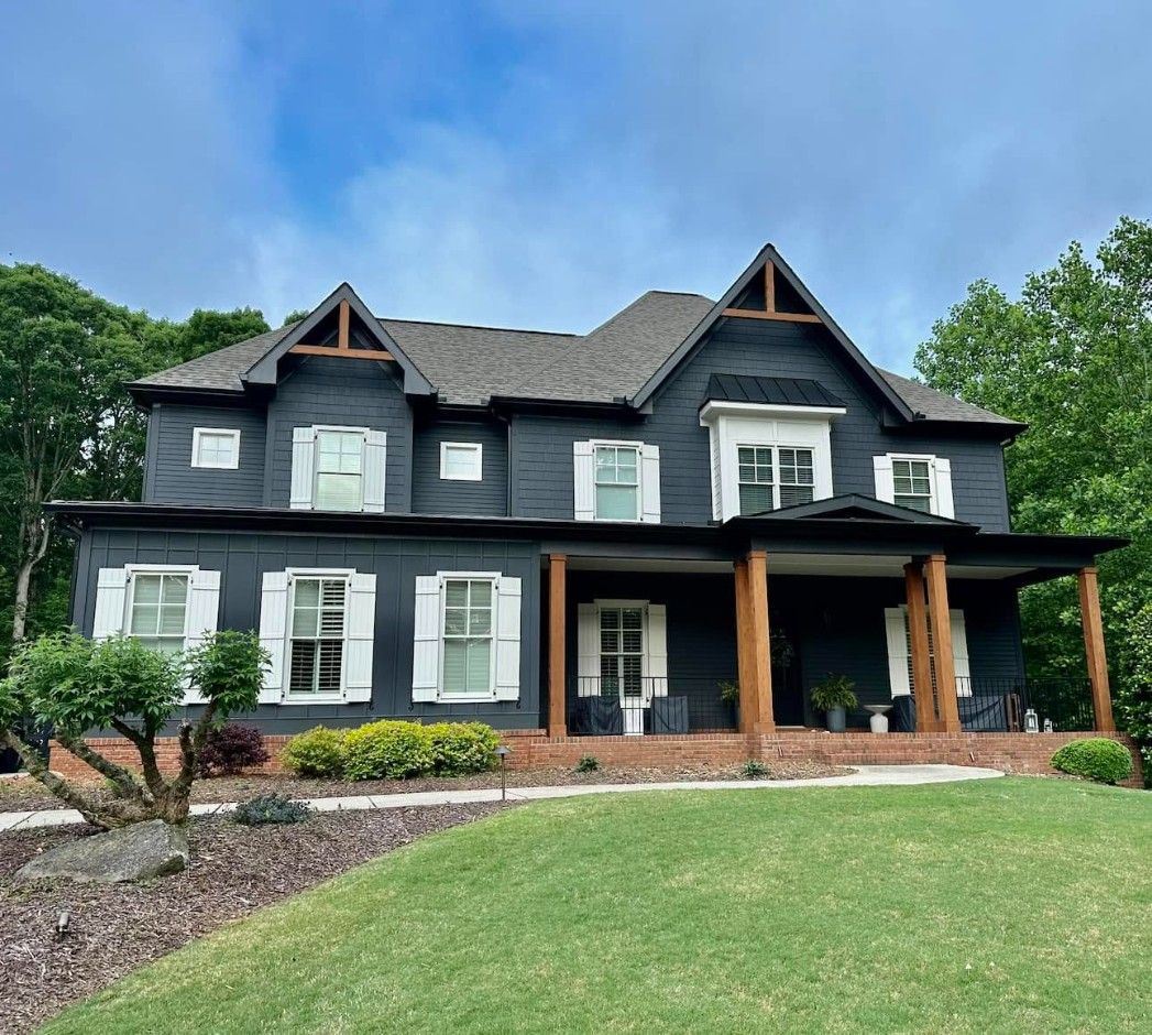 Charcoal two-story home with white shutters and cedar porch columns