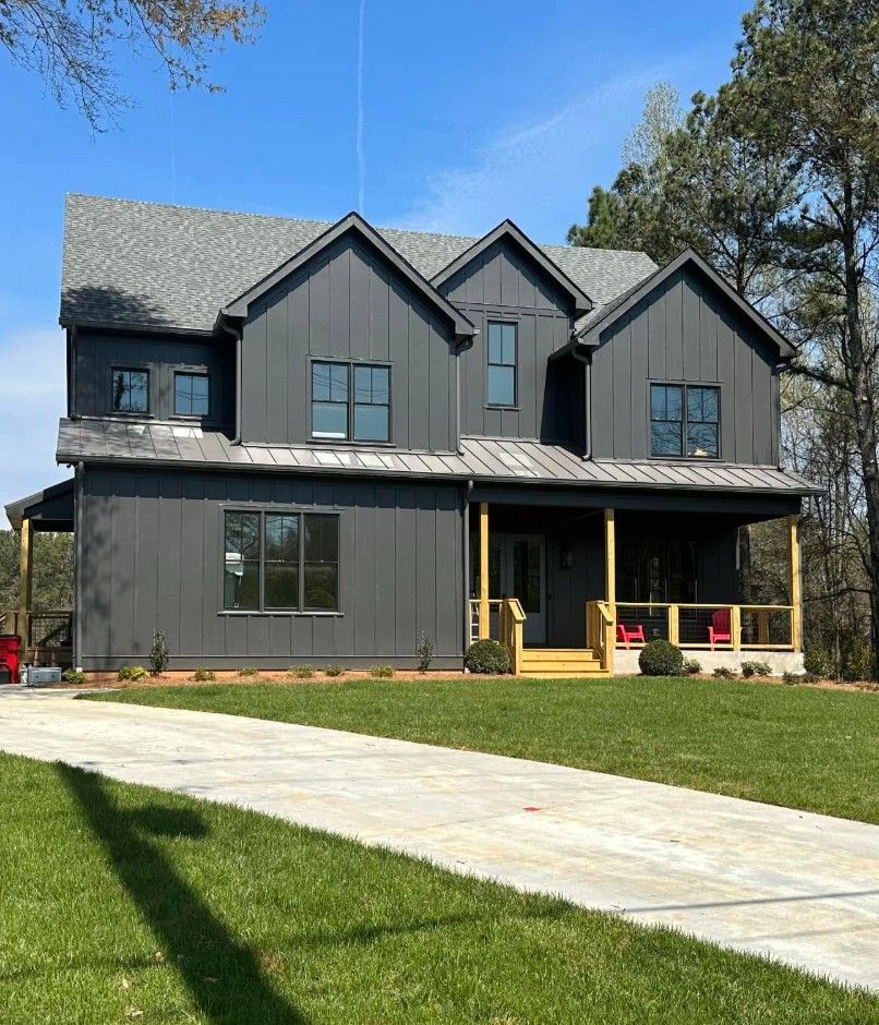 Charcoal board-and-batten home with natural wood porch posts