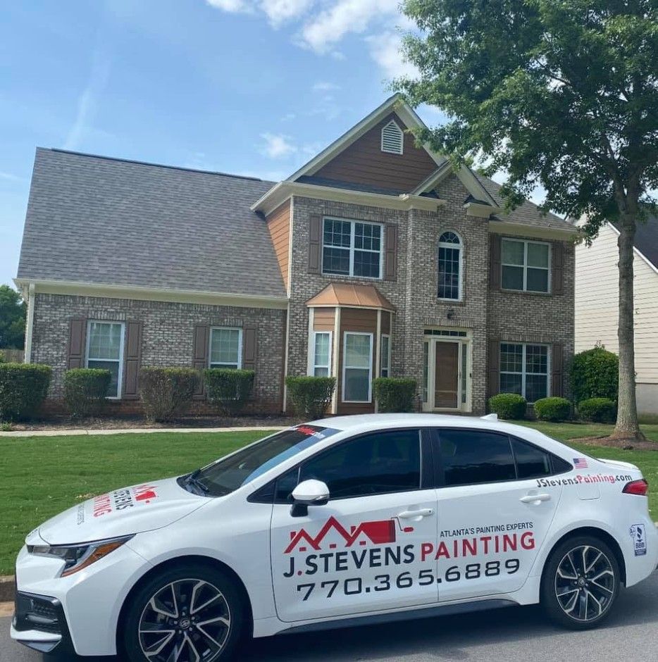 Mableton, GA brick-front home with fresh exterior paint and the J. Stevens Painting car out front
