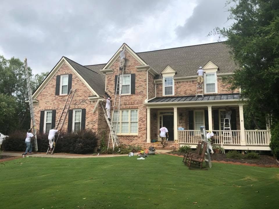 J. Stevens Painting crew prepping a brick home's trim on ladders