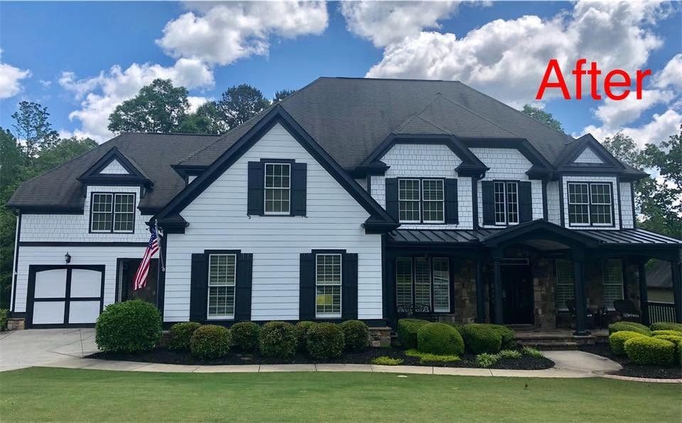 Two-story home painted white with black shutters and trim, after